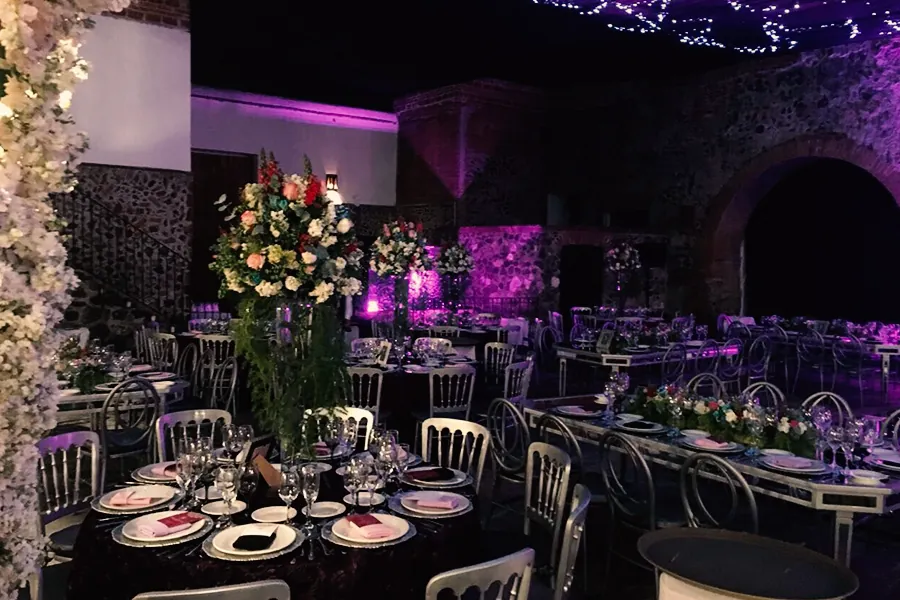 banquete-para-cena-de-gala-y-maridaje-montaje-elegante-con-iluminacion-morada-y-arreglos-florales-altos